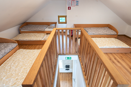 Mansardna spalnica z lesenimi tramovi